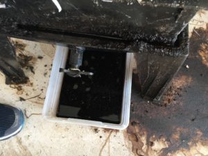 Birdseye view of a worm composting bin with black liquid overflow