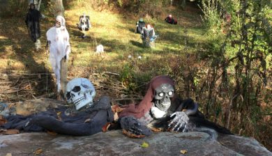 scary halloween goblins and ghosts hiding behind rocks in a front yard