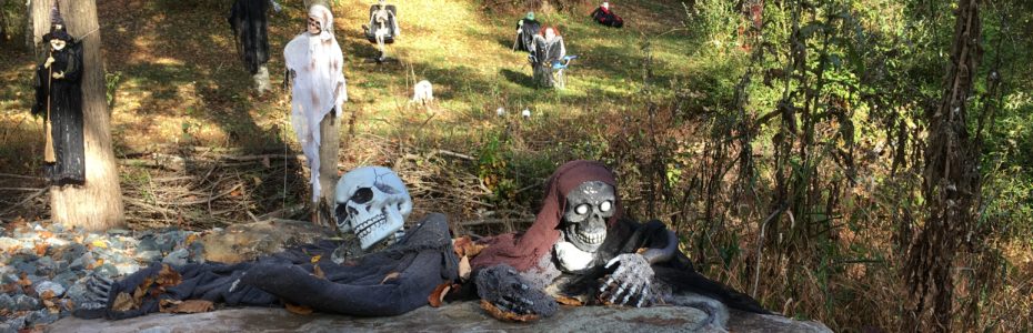 scary halloween goblins and ghosts hiding behind rocks in a front yard