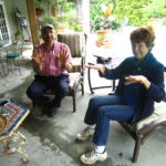 Ken Druse in a red checked shirt sitting with Marty Carson wearing blue showing their hands of the Two best Gardeners of the Garden State.