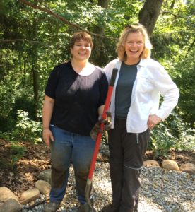 Stephanie, a gal with short brown hair, standing with Mary Stone after planting day. 