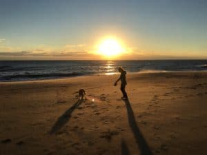 Virginia Beach Sunrise with a silhouette of Mary Stone and her golden retriever Miss Ellie Mae.