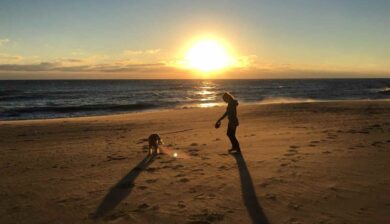 Virginia Beach Sunrise with a silhouette of Mary Stone and her golden retriever Miss Ellie Mae.