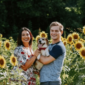 young woman and man with dog in sunflower field