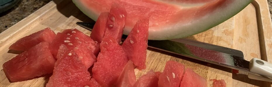 a cut up seedless watermelon on cutting board