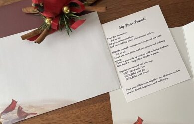 a mysterious unaddressed Christmas Card opened up on a wooden table with a red cardinal decoration
