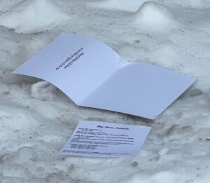 a mysterious unaddressed Christmas card in snow on the side of the road