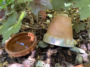 an upside down terracotta pot and saucer filled with water