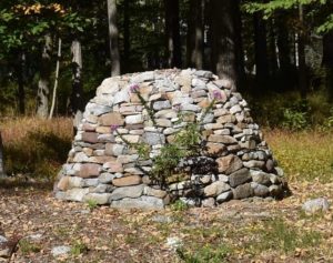 a large mound of boulders stacked neatly on the edge of a garden.