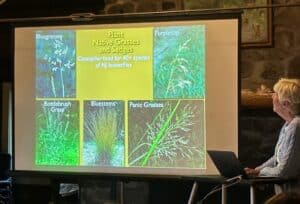 white haired lady, Sharon Wander, sharing a slide of Native Grasses and Sedges.