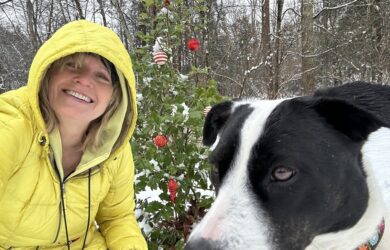 Mary Stone in a yellow jacket with Jolee in front of Ellie's memorial holly.