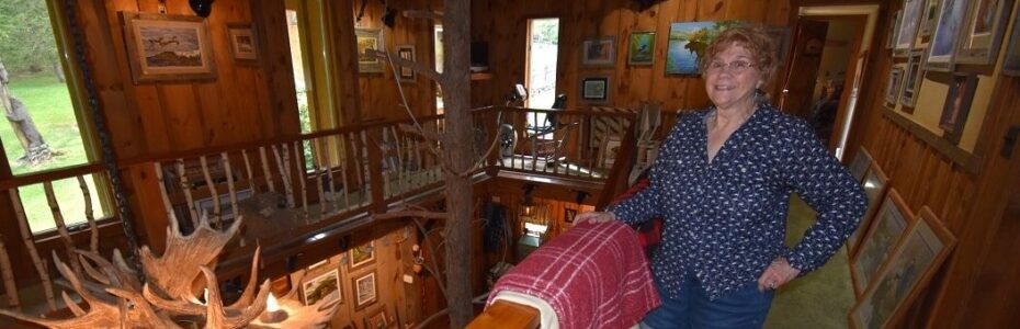 Carol Decker standing next to a railing of her home.