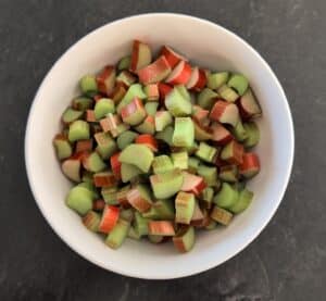 Freshly cut rhubarb pieces in a white bowl ready for pie