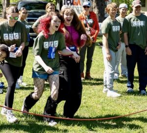 Campers and volunteers participating in an outdoor challenge course activity at Comfort Zone Camp.