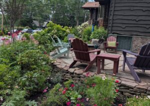 Colorful cottage garden surrounding a natural stone patio during the Warwick garden tour.