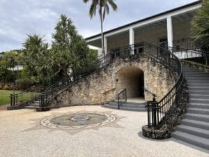 Historic stone entrance with curved staircases and a circular mosaic courtyard at Fairchild Tropical Botanic Garden.